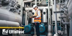 Worker with hard hat and computer diagnosing machinery