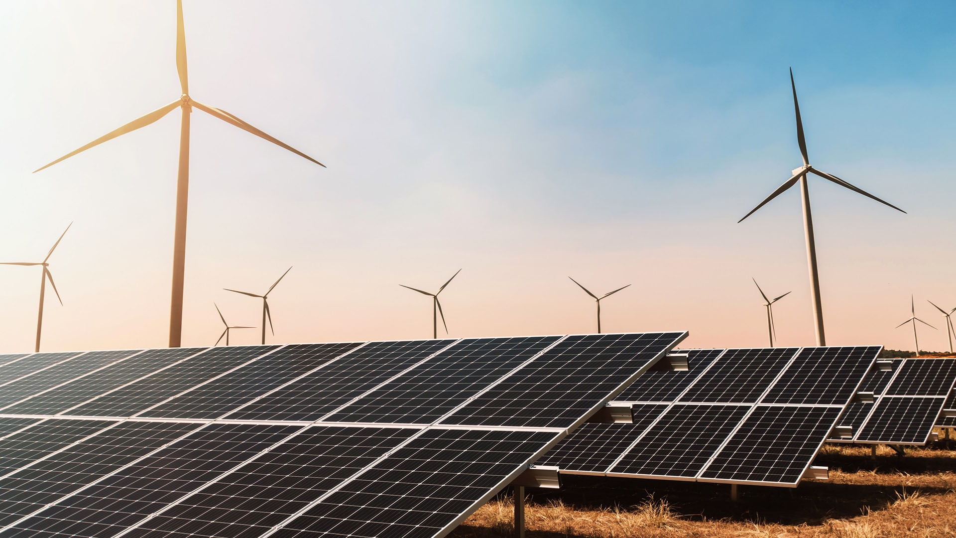 Two individuals work together with a robotic arm in an industrial setting. 