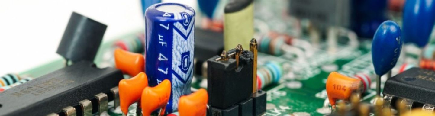 Eine detaillierte Ansicht einer elektronischen Leiterplatte mit Kondensatoren, Widerständen und Steckverbindern.