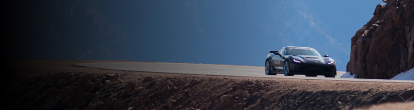 Imagen de un coche deportivo en una carretera sinuosa a través de las montañas