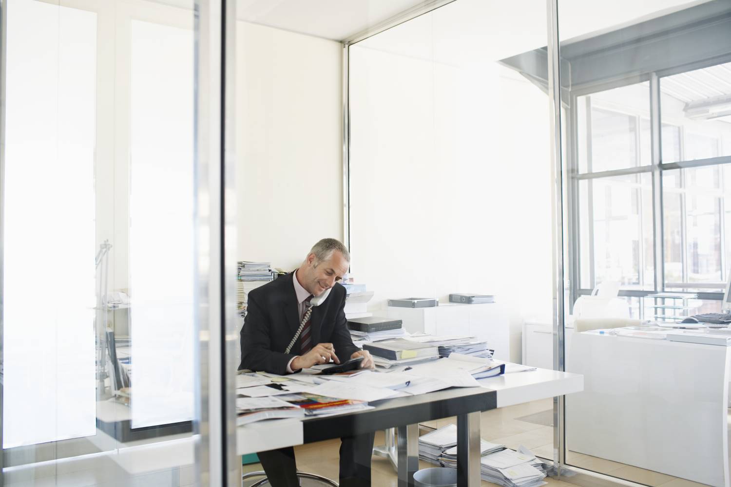 Businessman_Working_at_Desk_on_Phone Businessman_Working_at_Desk_on_Phone