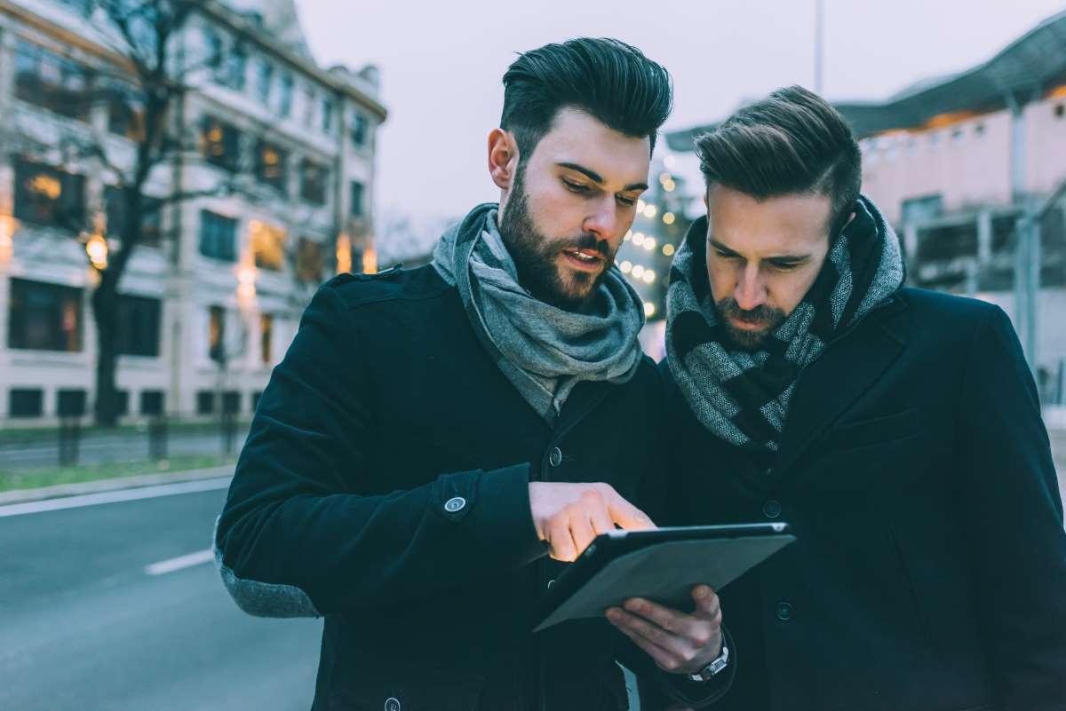 Two Men Using Tablet Outside
